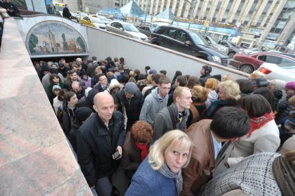 Толпа людей у подземного перехода во время открытия фестиваля `Рыбная неделя` на Пушкинской площади в Москве.