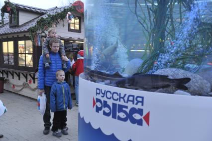 Прохожие рассматривают гигантский аквариум на Тверском бульваре, установленный в рамках фестиваля `Рыбная неделя` в Москве.