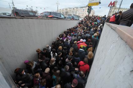 Толпа людей  у подземного перехода во время открытия фестиваля `Рыбная неделя` на Пушкинской площади  в Москве.