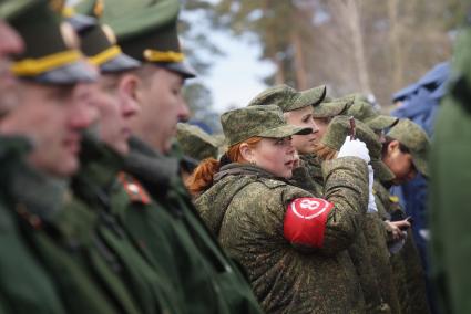 Военнослужащая-женщина смотрится в зеркальце, во время тренировки парадных расчетов на территории 32-го военного городка в Екатеринбурге