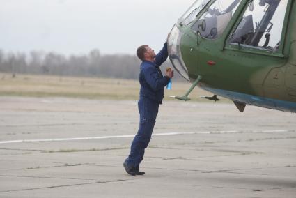 Пилот протирает стекла кабины вертолета Ми-8 на авиабазе \"Каменск-Уральский\". Каменск-Уральский