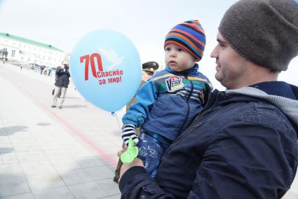 Мужчина с ребенком на руках, во время проведения всероссийской акции памяти \"70. Спасибо за мир\". Екатеринбург