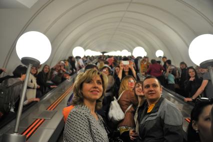 Празднования Дня Победы в Москве. Люди поднимаются по эскалатору на станции метро `Парк Победы`.