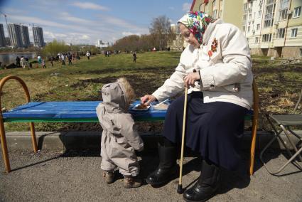 Бабушка-ветеран гуляет с внуком на аллее. Екатеринбург