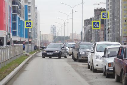 Дорога в новом, строящемся районе \"Академический\" заставленная припарковаными автомобилями. Екатеринбург