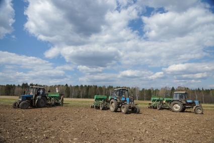 Тракторы в поле, во время сева картофеля. Сельскохозяйственный производственный кооператив «Битимский». Свердловская область