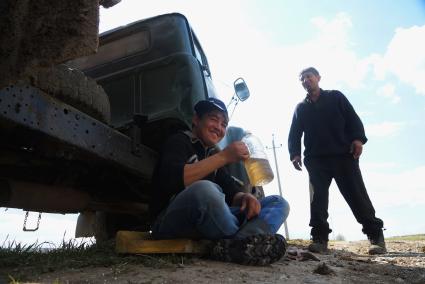 Рабочий пьет чай сидя у грузовика с удобрениями, во время сева картофеля. Сельскохозяйственный производственный кооператив «Битимский». Свердловская область