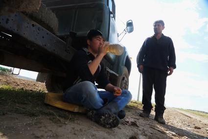 Рабочий пьет чай сидя у грузовика с удобрениями, во время сева картофеля. Сельскохозяйственный производственный кооператив «Битимский». Свердловская область