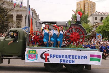 Украина. Донецк. Трактор `стахановки` Паши Ангелиной на автомобиле Краз с транспарантом `Старобешевский район` во время парада, посвященного годовщине проведения референдума о самоопределении Донецкой Народной Республики, на улице Артема.