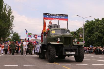 Украина. Донецк.  Трактор `стахановки` Паши Ангелиной на автомобиле Краз с транспарантом `Старобешевский район` во время парада, посвященного годовщине проведения референдума о самоопределении Донецкой Народной Республики, на улице Артема.