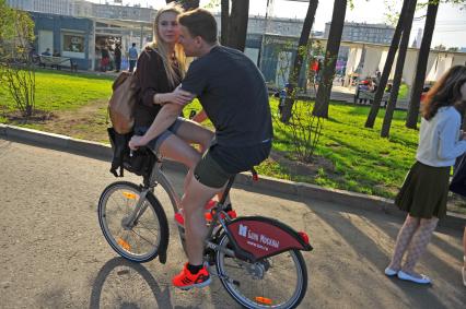 Молодой человек с девушкой на велосипеде в Центральном парке Культуры и Отыха им. Горького в Москве.