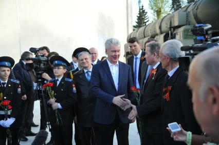 Мэр Москвы Сергей Собянин (в центре) и руководитель Федерального космического агентства (Роскосмос) Игорь Комаров (третий справа) во время общения с журналистами после осмотра выставки образцов российского вооружения у павильона `Космос` на ВДНХ в Москве.