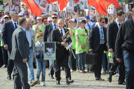 Москва. Президент РФ Владимир Путин (в центре) шествует по Красной площади вместе с учатниками акции `Бессмертный полк`, посвященной 70-летию Победы в Великой Отечественной войне.