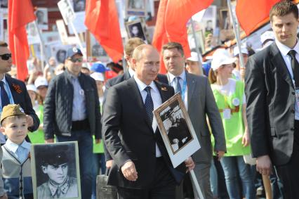 Москва. Президент РФ Владимир Путин (в центре) шествует по Красной площади вместе с учатниками акции `Бессмертный полк`, посвященной 70-летию Победы в Великой Отечественной войне.