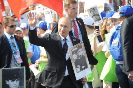 Москва. Президент РФ Владимир Путин (в центре) шествует по Красной площади вместе с учатниками акции `Бессмертный полк`, посвященной 70-летию Победы в Великой Отечественной войне.