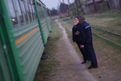 Проводница и машинист поезда во время остановки на станции Тимошина. По Алапаевской узкоколейной железной дороге, 1 раз в неделю по четвергам, на почтовом вагоне в составе пасажирского поезда доставляют почту, и продукты для магазинов в отдаленные деревни и села направлении поселка Махнево. Алапаевск