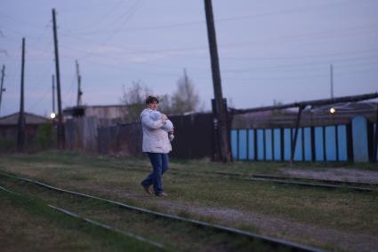 Женщина с грудным ребенком гуляет во время остановки поезда ст.Тимошина. По Алапаевской узкоколейной железной дороге, 1 раз в неделю по четвергам, на почтовом вагоне в составе пасажирского поезда доставляют почту, и продукты для магазинов в отдаленные деревни и села направлении поселка Махнево. Алапаевск