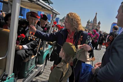 Москва. Люди дарят цветы ветеранам после Парада на Красной площади, в честь 70-летия Победы в Великой Отечественной войне.