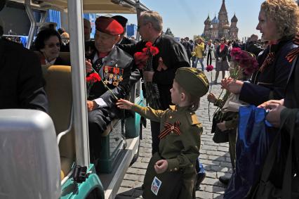 Москва. Люди дарят цветы ветеранам после Парада на Красной площади, в честь 70-летия Победы в Великой Отечественной войне.