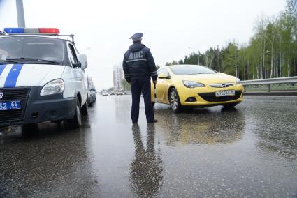 Полицейский ГИБДД с жезлом, останавливает машину во время рейда. Екатеринбург