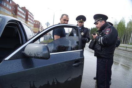 Полицейский ГИБДД с аппаратом ИСС-1 (Измеритель светопропускания стекол), проверяет коэффициент светопропускания стекла во время рейда. Екатеринбург