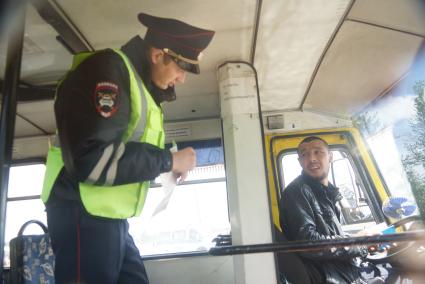 Полицейские ГИБДД проверяед документы у водителя маршрутного автобуса, во время рейда по выявлению неисправных маршруток. Екатеринбург