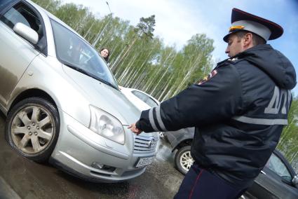 Полицейский ГИБДД останавливает автомобиль с спущеным колесом во время рейда. Екатеринбург