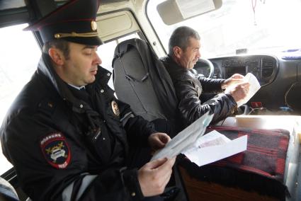 Полицейские ГИБДД проверяет документы у водителямаршрутного автобуса, во время рейда по выявлению неисправных маршруток. Екатеринбург
