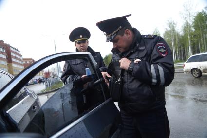 Полицейский ГИБДД с аппаратом  ИСС-1 (Измеритель светопропускания стекол), проверяет коэффициент светопропускания стекла во время рейда. Екатеринбург