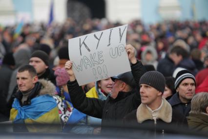 Киев. Акция сторонников Евроинтеграции Украины на Михайловской площади. Активист держит плакат `Киев, проснись!`.