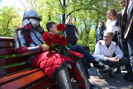 Выпускники школы празднующие последний звонок, рассматривают рыцарские доспехи парня, пришедшего на свидание. Екатеринбург