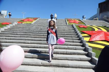 Выпускница школы гуляет по плотинке, во время празднования последнего звонка.  Екатеринбург