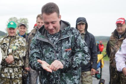 Полномочный представитель президента в УрФО Игорь Холманских (в центре) чеканит кувалдой памятную монетку на Демидовской пристани на реке Чусовая, в деревне Усть-Утка. Свердловская область