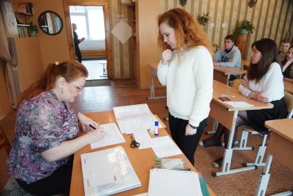 Учитель проверяет паспорт у школьницы, пришедшей на сдачу ЕГЭ. Школа №208. Екатеринбург