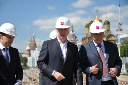 Мэр Москвы Сергей Собянин (в центре) и заместитель мэра Москвы по вопросам градостроительной политики и строительства Марат Хуснуллин (направа) во время осмотра хода работ по созданию парка `Зарядье` в Москве.