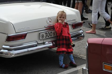 Девочка у Mercedes-Benz 380 SL во время ралли ретро-авто в Москве.