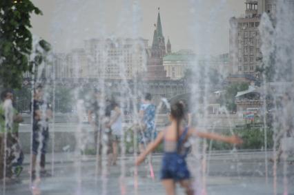 Москва. Парк искусств `Музеон`. Люди гуляют под струями фонтана.