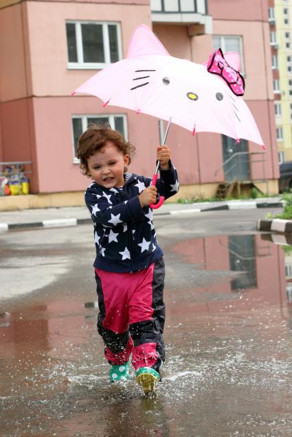 Москва. Девочка бегает по лужам под зонтиком.