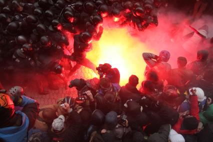 Евромайдан. Активисты Евромайдана атакуют сотрудников спецподразделения `Беркут`, не дающих им прорваться к зданию администрации президента на Банковой улице.