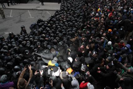 Евромайдан. Активисты Евромайдана атакуют сотрудников спецподразделения `Беркут`, не дающих им прорваться к зданию администрации президента на Банковой улице.