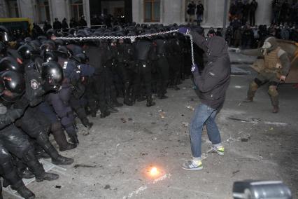 Евромайдан. Активисты Евромайдана атакуют сотрудников спецподразделения `Беркут`, не дающих им прорваться к зданию администрации президента на Банковой улице.