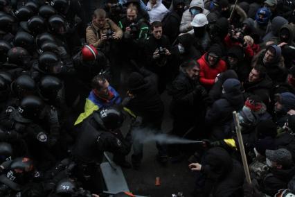 Евромайдан. Активисты Евромайдана атакуют сотрудников спецподразделения `Беркут`, не дающих им прорваться к зданию администрации президента на Банковой улице.