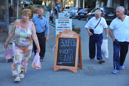 Алушта. Надпись на вывеске у ресторана `Здесь много еды`.