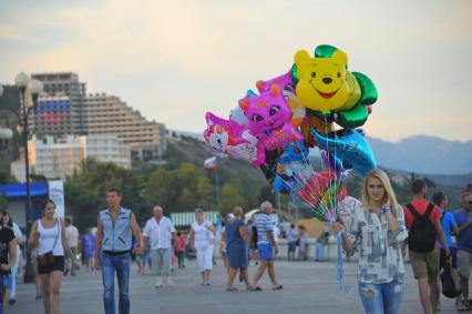 Алушта. Девушка продает надувные шарики на набережной.