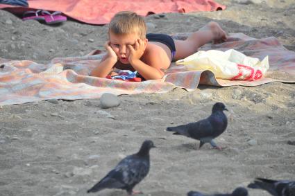 Алушта. Мальчик загорает на пляже.