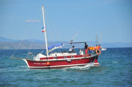 Алушта. Мужчины плавают на яхте.