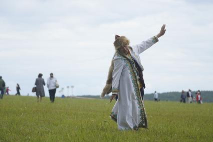 Мужчина в национальном Башкирском костюме танцует в поле, во время празднования Сабантуя. село Кадниово. Свердловская область