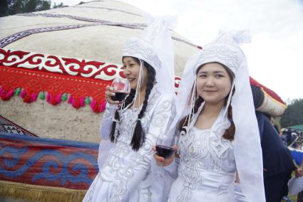 Девушки в национальном Башкирском свадебном наряде с бокалами вина, во время празднования Сабантуя. село Кадниово. Свердловская область
