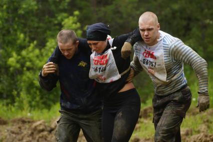 Участники военно-спортивной игры \"Гонка героев\", помогают травмировавшейся девушке, во время преодоления очередного препятствия. Танковый полигон 32-го военного городка. Екатеринбург