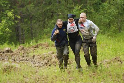 Участники военно-спортивной игры \"Гонка героев\", помогают травмировавшейся девушке, во время преодоления очередного препятствия. Танковый полигон 32-го военного городка. Екатеринбург